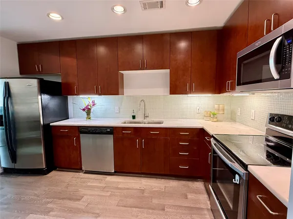 a kitchen with stainless steel appliances granite countertop a sink and a stove