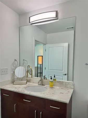 a bathroom with a granite countertop sink and a mirror