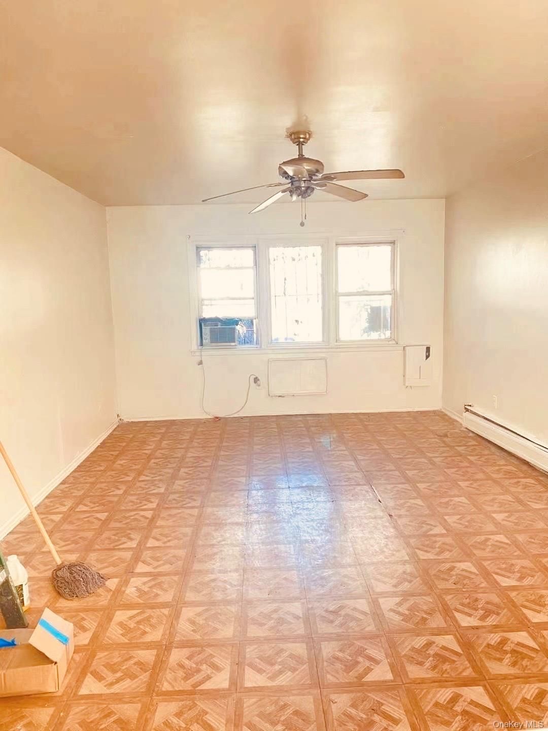41-08 111th Street Queens, NY 11368 - Photo 8 of 9 a view of empty room with wooden floor and fan