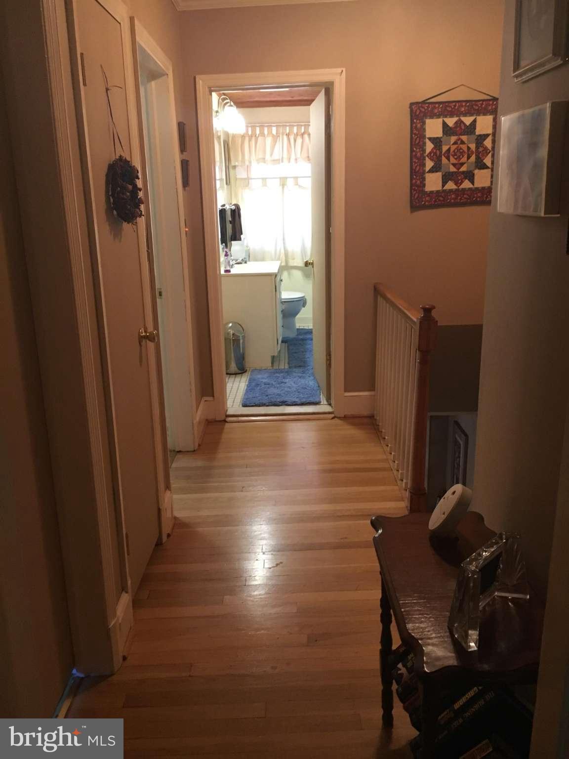6010 Falkirk Road Baltimore, MD 21239 - Photo 30 of 30 a view of a hallway with wooden floor and a livingroom