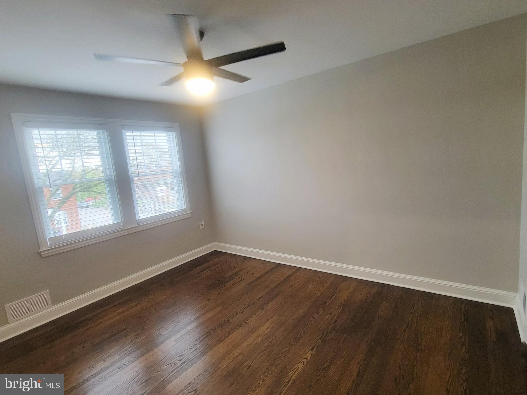 202 Edgewood Street Baltimore, MD 21229 - Photo 15 of 29 an empty room with wooden floor and windows
