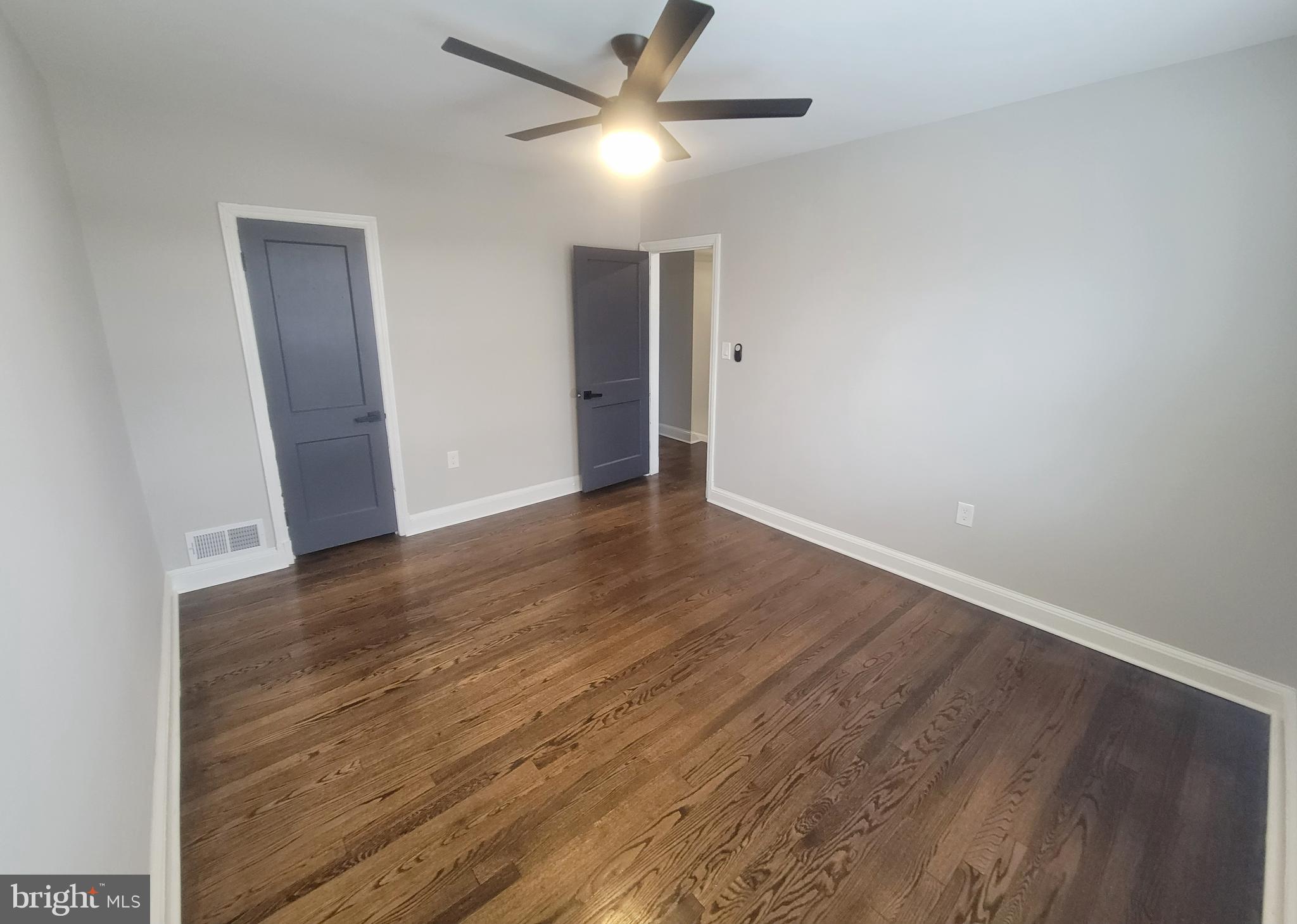 202 Edgewood Street Baltimore, MD 21229 - Photo 16 of 29 an empty room with wooden floor and a ceiling fan