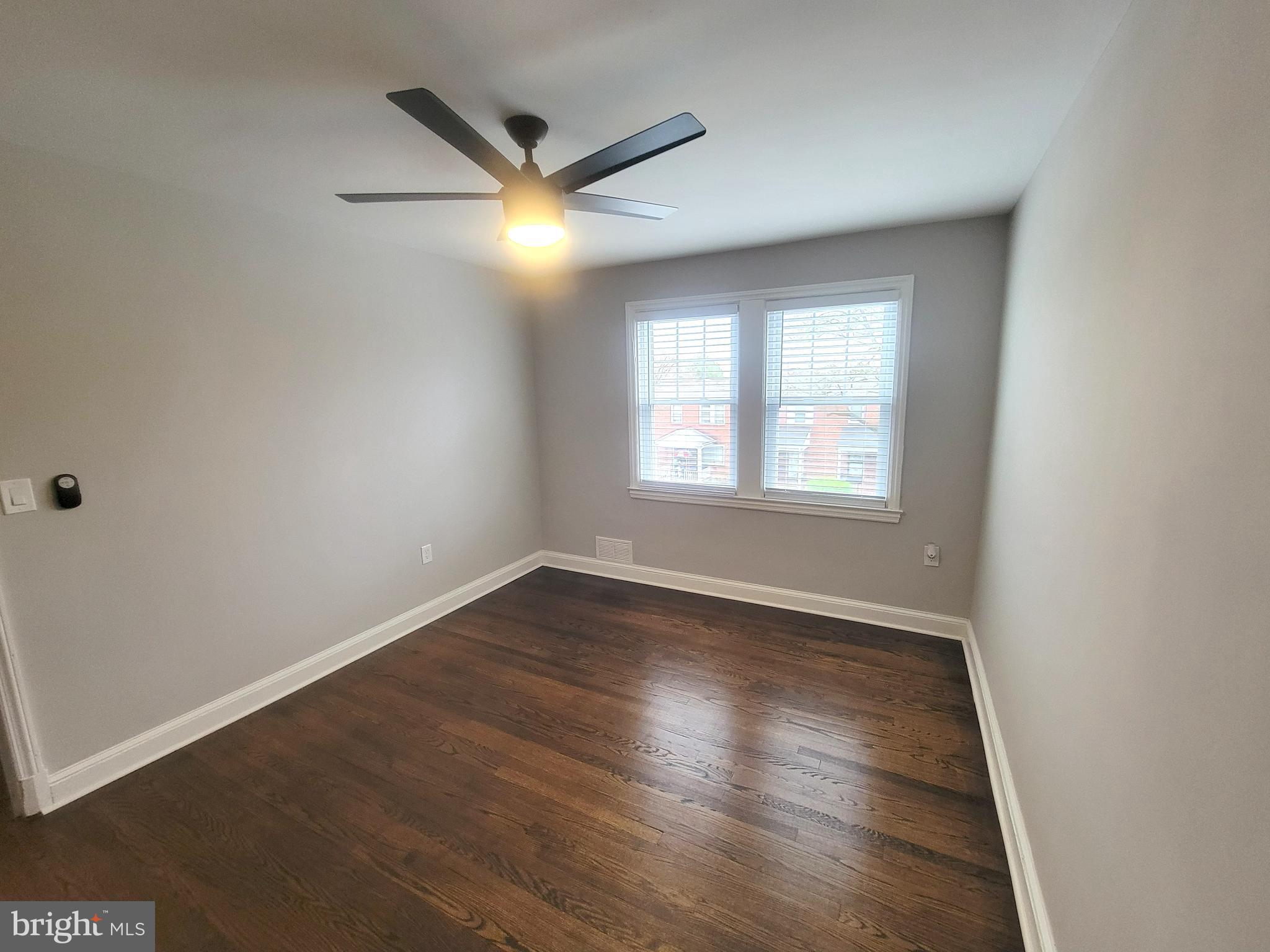 202 Edgewood Street Baltimore, MD 21229 - Photo 17 of 29 an empty room with wooden floor and windows