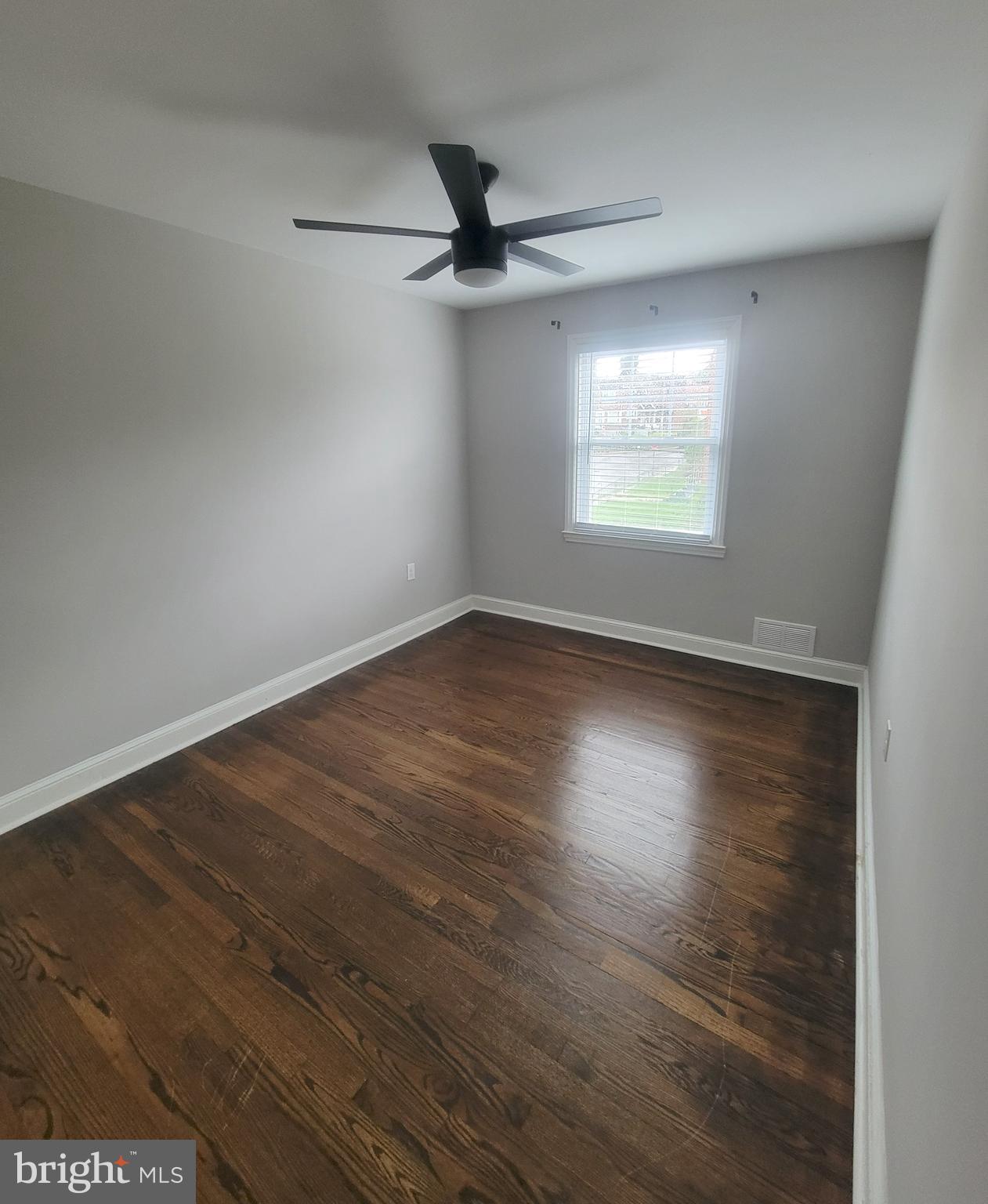 202 Edgewood Street Baltimore, MD 21229 - Photo 18 of 29 an empty room with wooden floor fan and windows