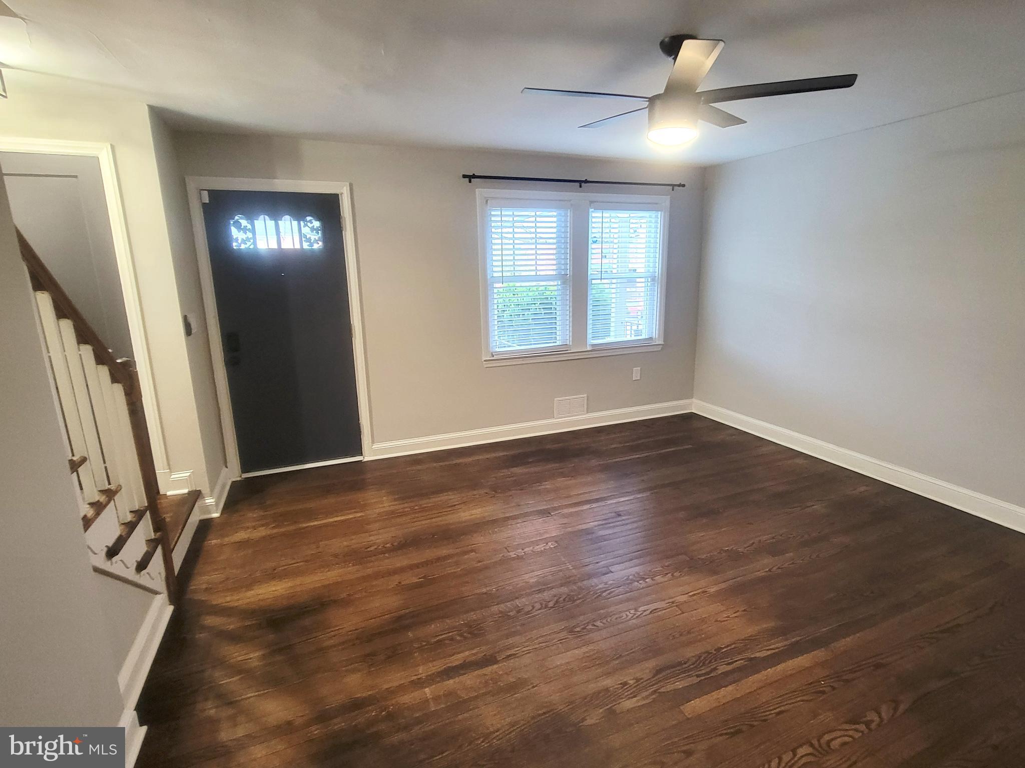 202 Edgewood Street Baltimore, MD 21229 - Photo 2 of 29 an empty room with wooden floor and windows