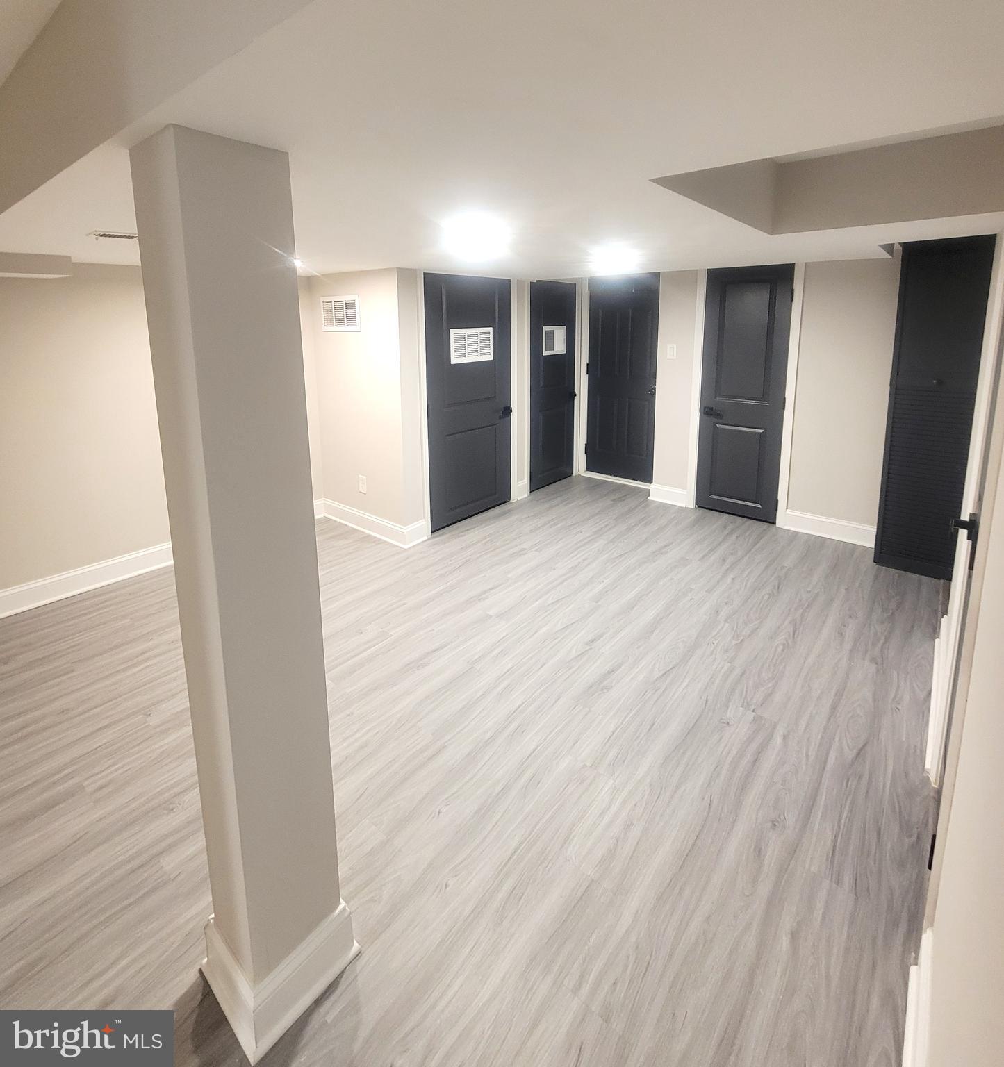 202 Edgewood Street Baltimore, MD 21229 - Photo 23 of 29 a view of an empty room with wooden floor and a bathroom