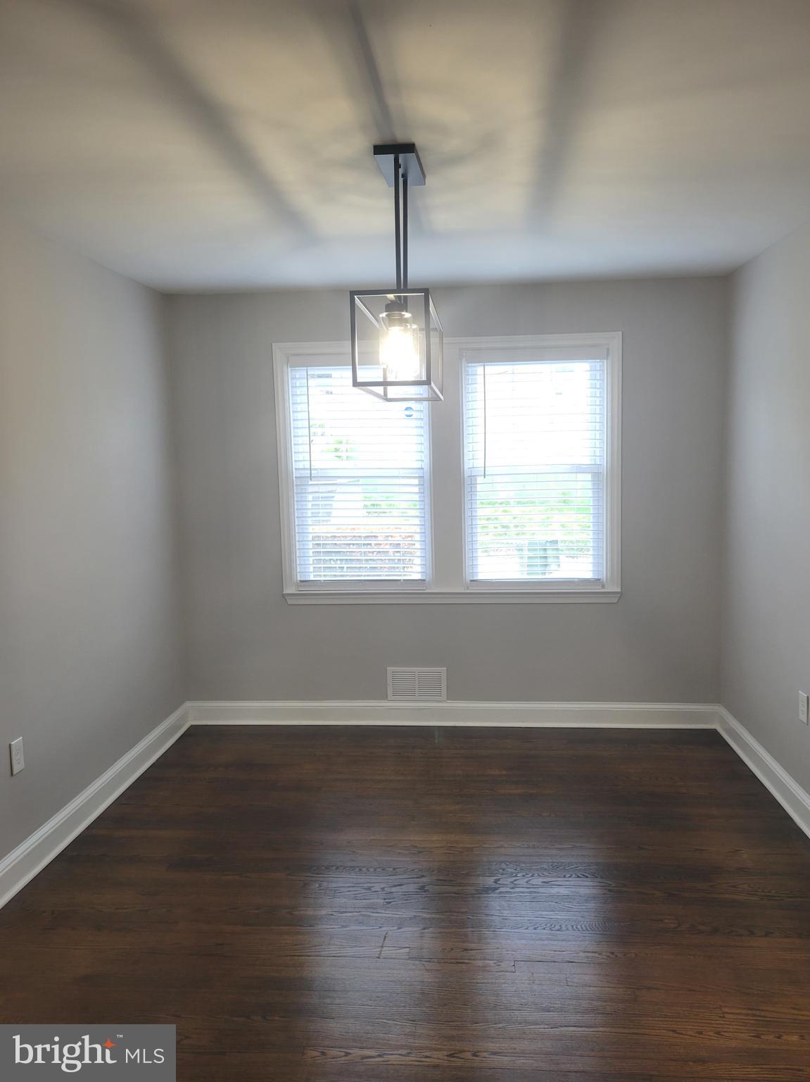 202 Edgewood Street Baltimore, MD 21229 - Photo 5 of 29 an empty room with wooden floor and windows
