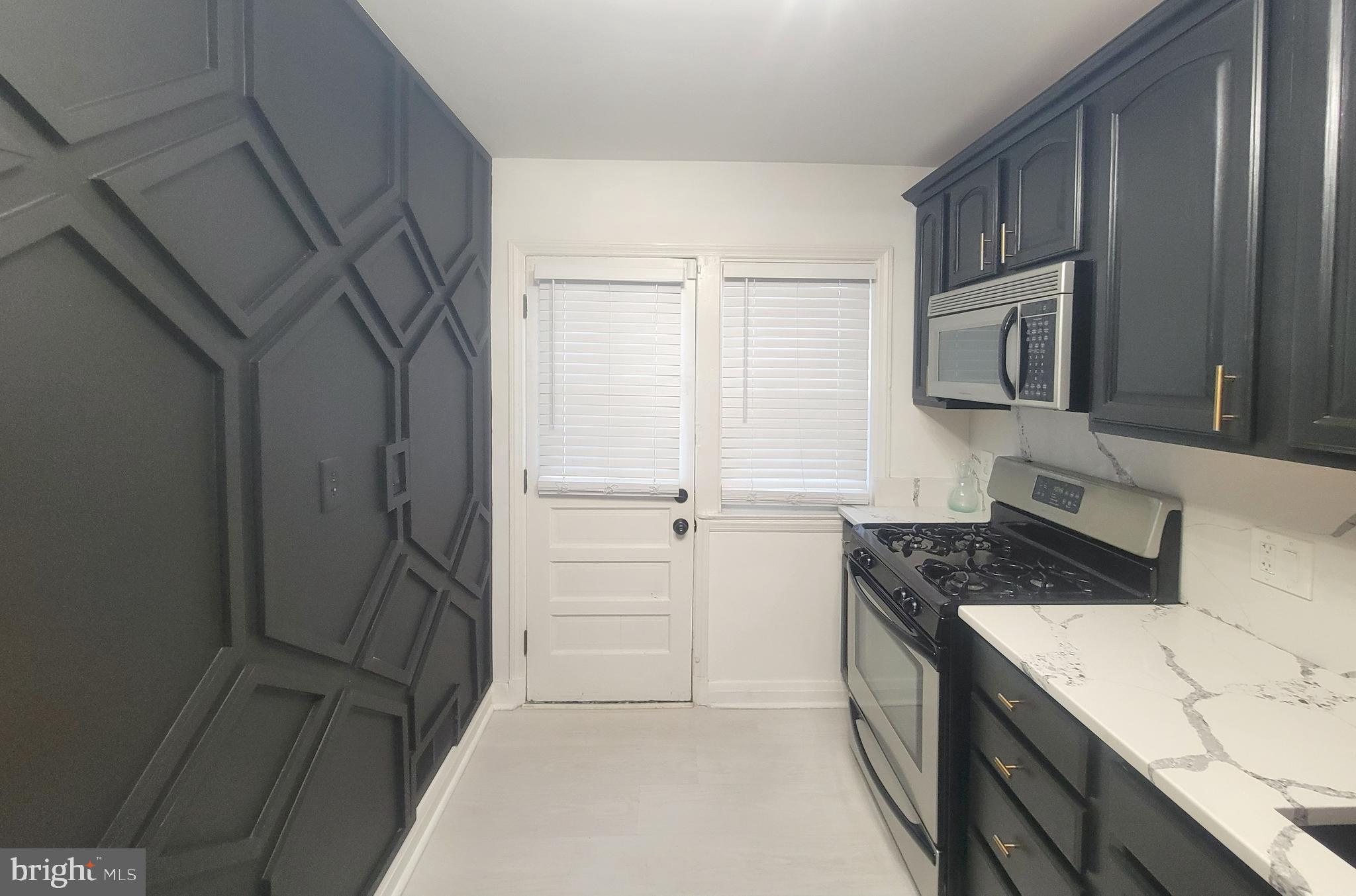 202 Edgewood Street Baltimore, MD 21229 - Photo 6 of 29 a kitchen with a refrigerator stove and cabinets