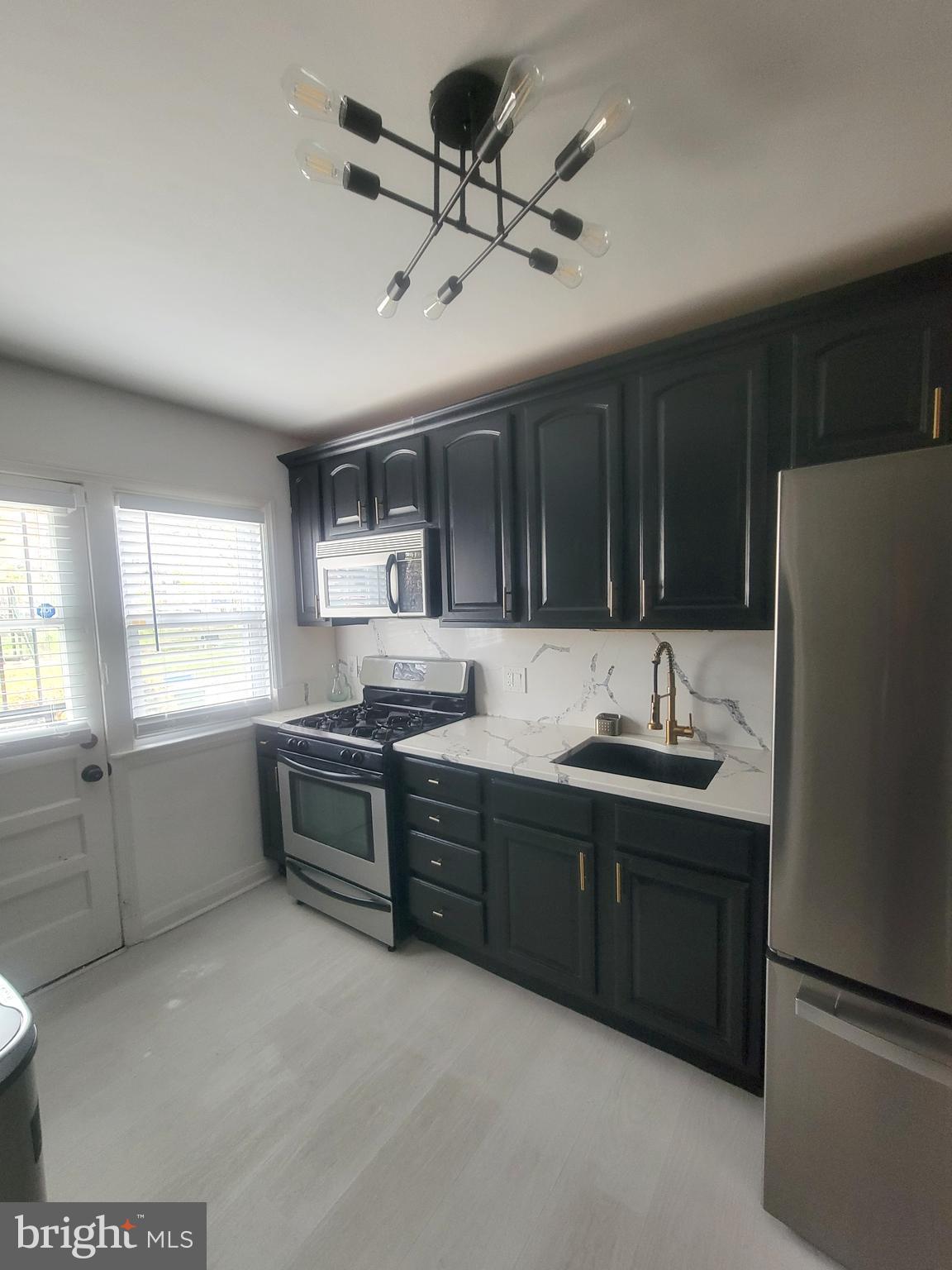 202 Edgewood Street Baltimore, MD 21229 - Photo 7 of 29 a kitchen with stainless steel appliances granite countertop a sink stove and refrigerator