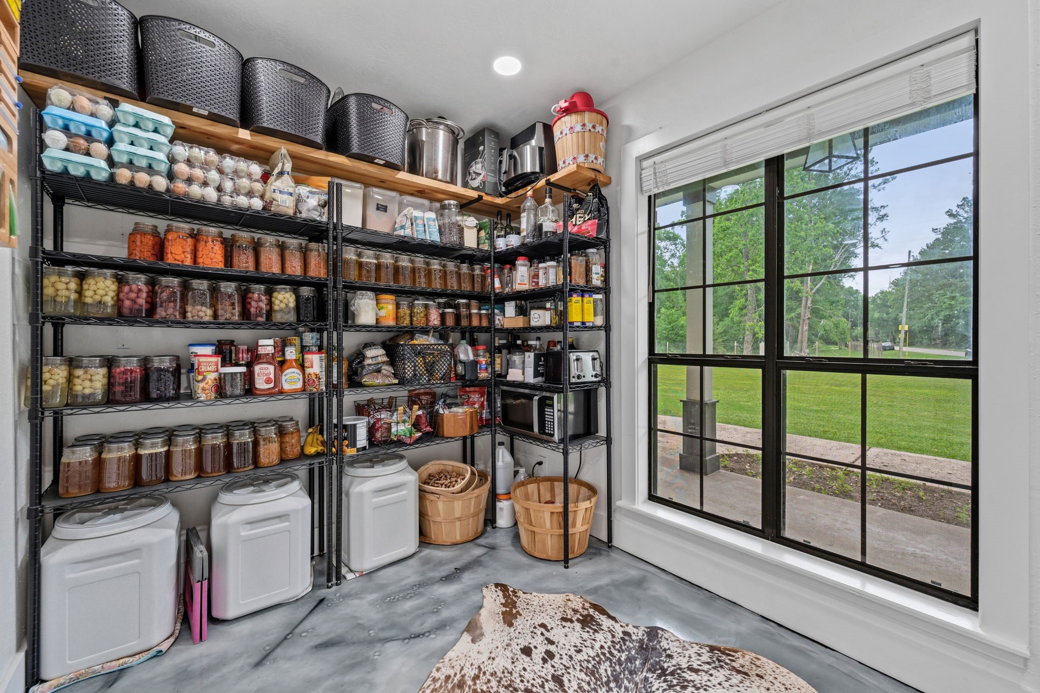 18 East Old Field Road Huffman, TX 77336 - Photo 14 of 35 The exceptionally spacious combined walk-in pantry and utility room offers extensive storage for kitchen essentials along with abundant functional workspace. An oversized window fills the area with natural light, elevating this highly practical space with a bright and airy ambiance.