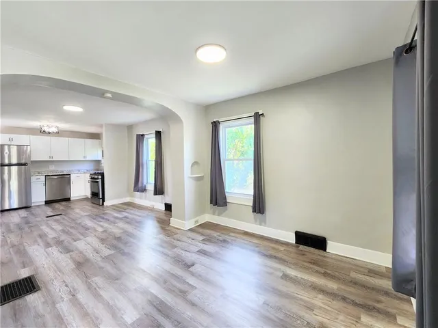 an empty room with wooden floor and fireplace