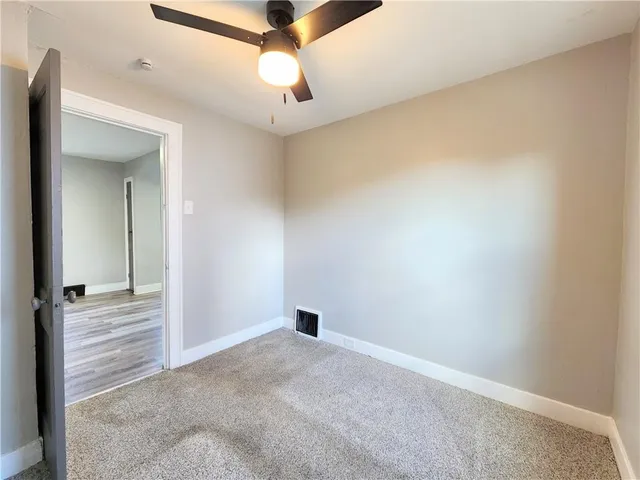 en empty room with ceiling fan and window