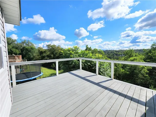 a view of a balcony with wooden floor and fence