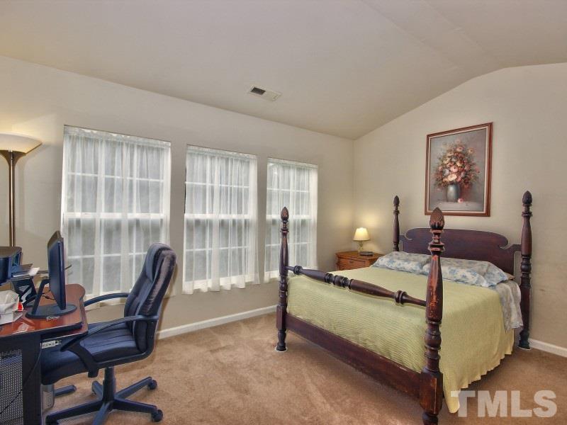 8523 Bright Loop Raleigh, NC 27613 - Photo 11 of 23 a bedroom with a bed and large windows