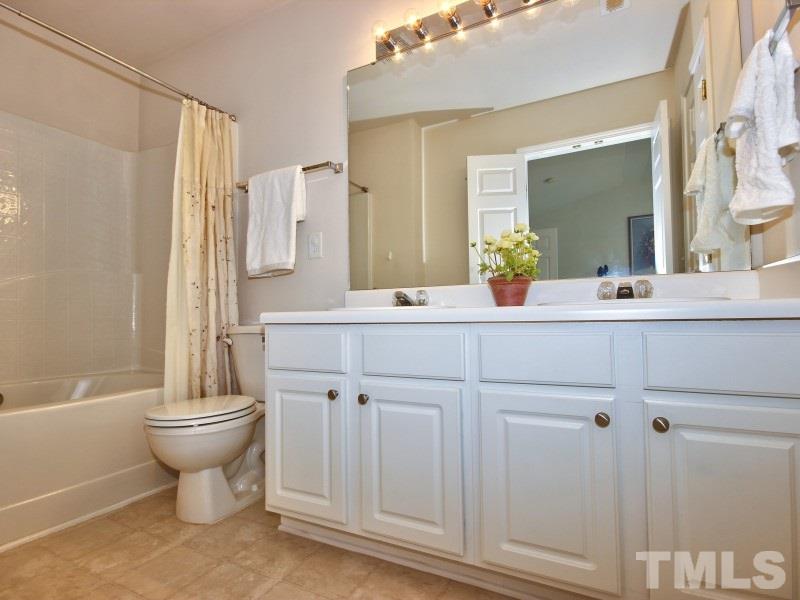 8523 Bright Loop Raleigh, NC 27613 - Photo 13 of 23 a bathroom with a double vanity sink toilet and a mirror