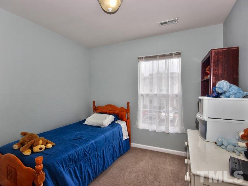 8523 Bright Loop Raleigh, NC 27613 - Photo 14 of 23 a bedroom with a bed and window