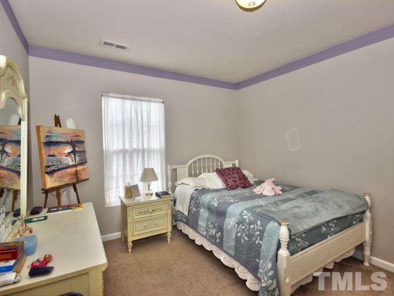 8523 Bright Loop Raleigh, NC 27613 - Photo 15 of 23 a bedroom with a bed and a window