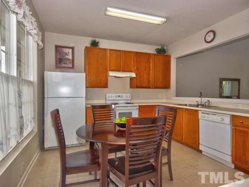 8523 Bright Loop Raleigh, NC 27613 - Photo 5 of 23 a kitchen with a table chairs and a refrigerator