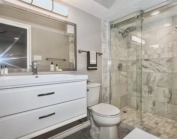 a bathroom with a sink toilet and shower