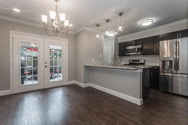 a kitchen with stainless steel appliances granite countertop a refrigerator microwave and stove top oven