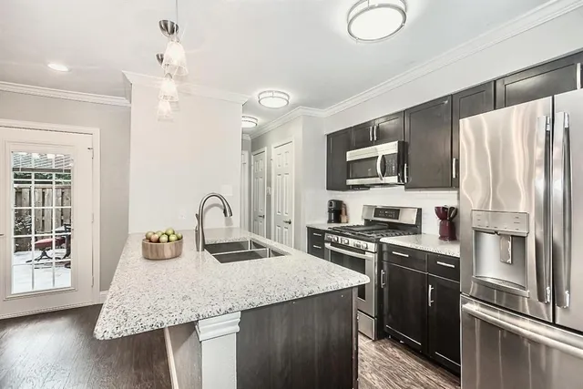 a kitchen with stainless steel appliances granite countertop a sink refrigerator stove and microwave