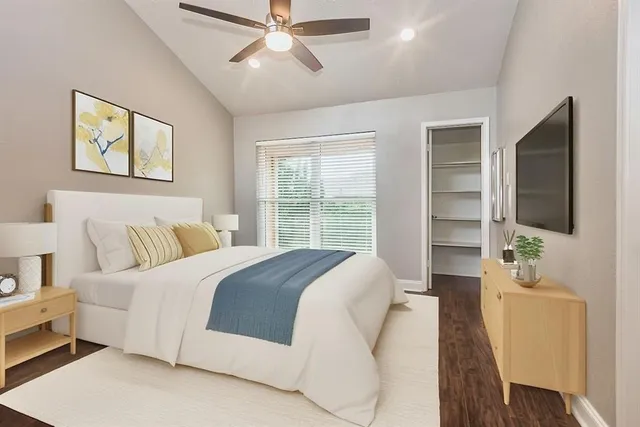 a spacious bedroom with a bed and a flat screen tv