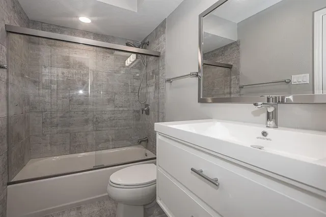 a bathroom with a shower a toilet and a sink