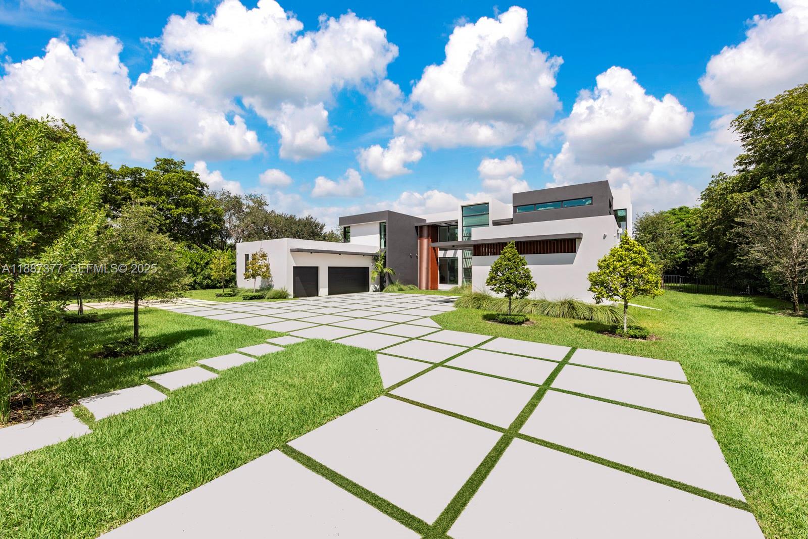 a view of a white house with a yard and plants