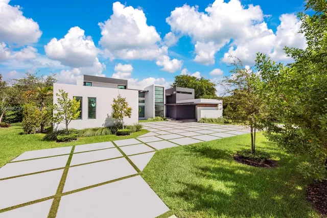 a front view of a house with a yard and a garden