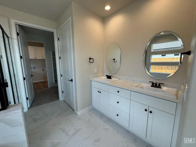 a spacious bathroom with double vanity a double vanity sink a mirror and a vanity