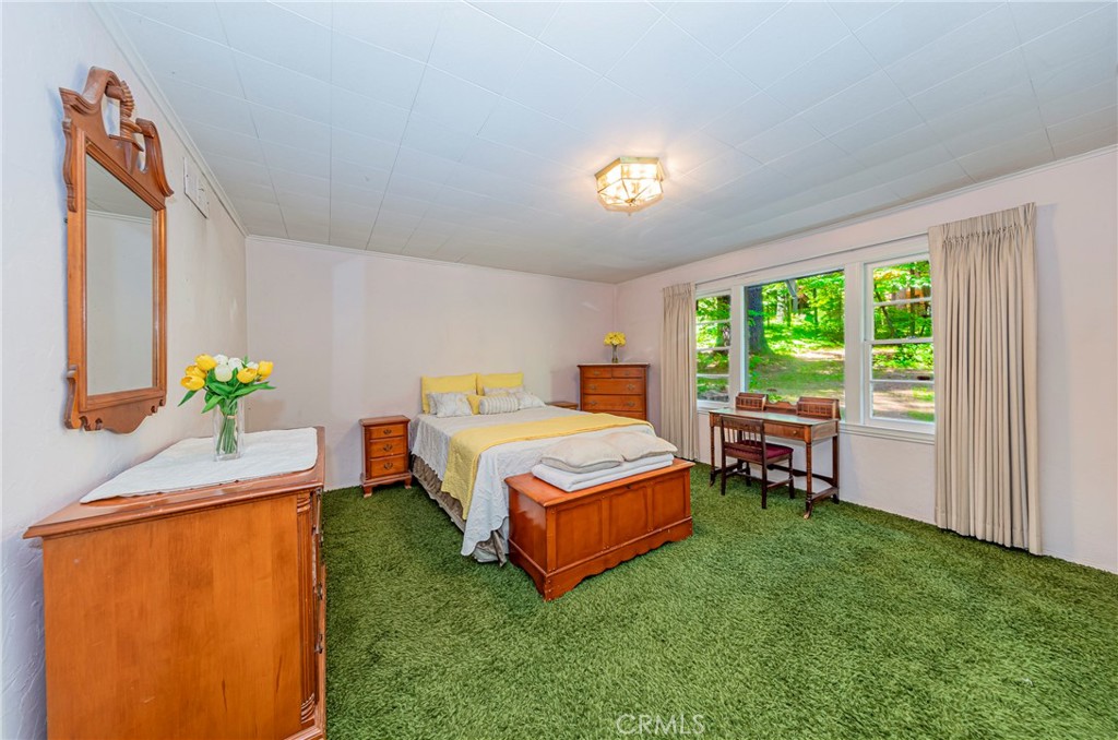 1173 Railroad Avenue Fish Camp, CA 93623 - Photo 21 of 75 a bedroom with a bed table chair and a window