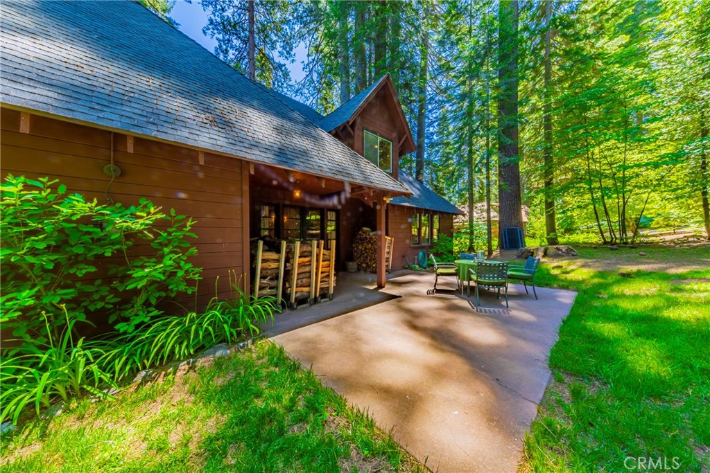 1173 Railroad Avenue Fish Camp, CA 93623 - Photo 56 of 75 a view of a backyard with table and chairs under an umbrella