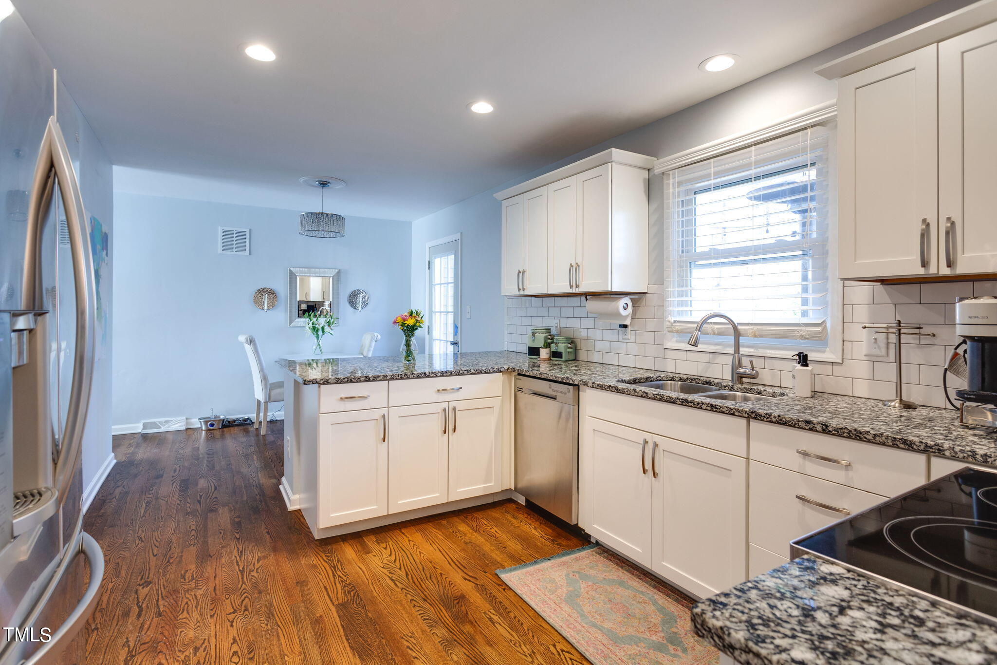 4904 Latimer Road Raleigh, NC 27609 - Photo 15 of 33 a kitchen with granite countertop a sink cabinets stainless steel appliances and a window