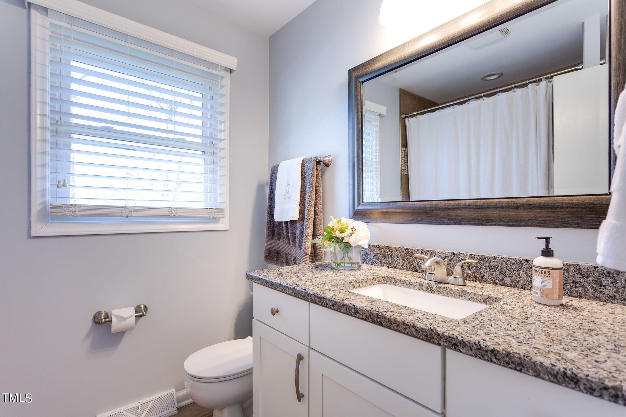 4904 Latimer Road Raleigh, NC 27609 - Photo 24 of 33 a bathroom with a granite countertop sink and a mirror