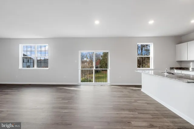 a view of a kitchen with wooden floor and a window