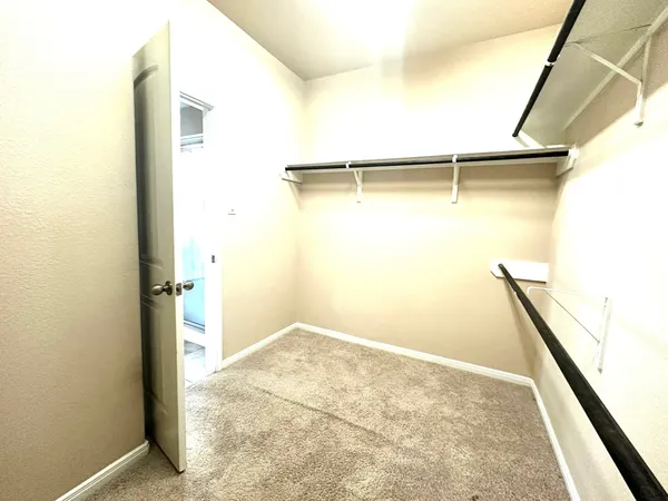a view of walk in closet with empty racks