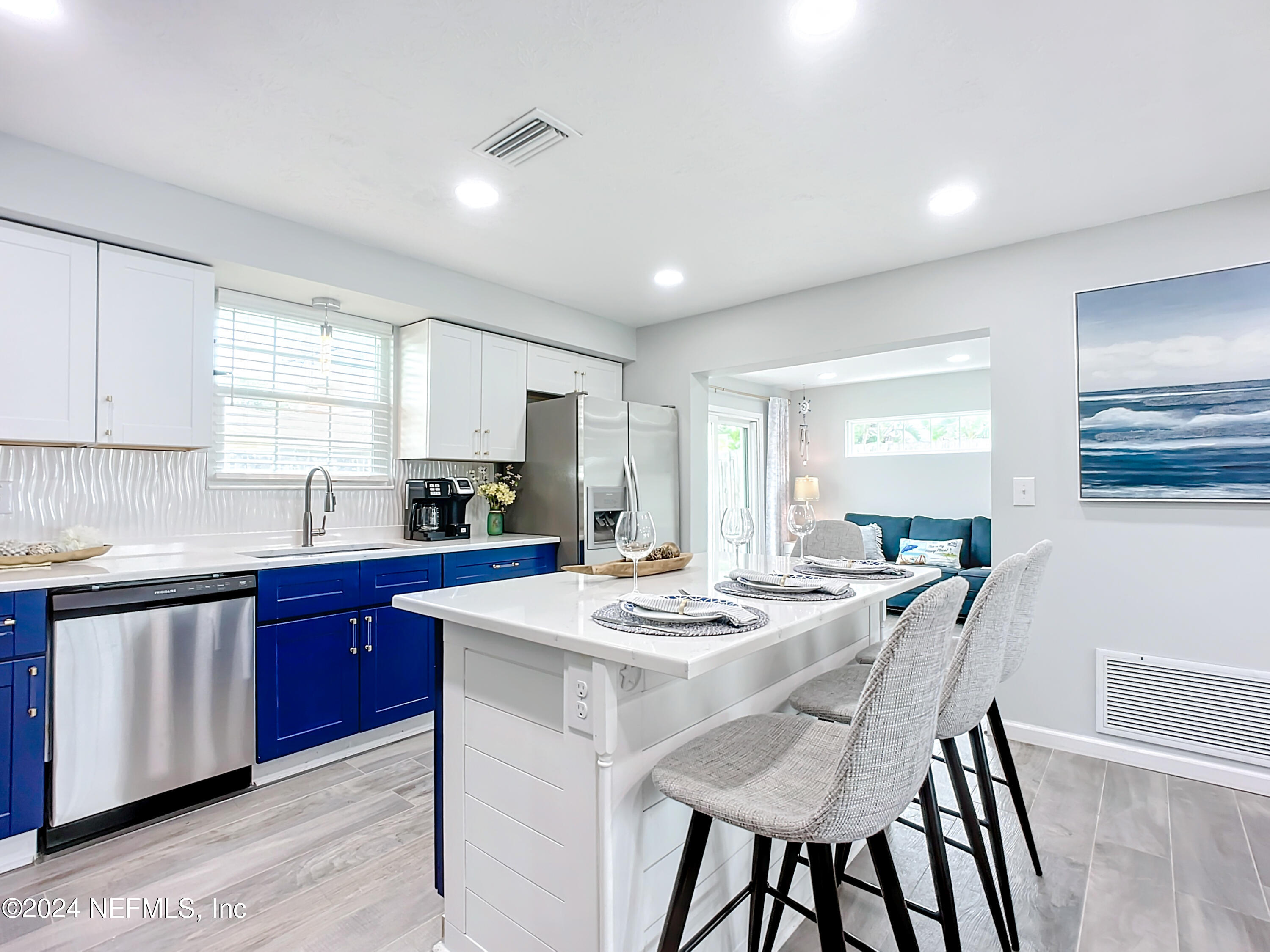 54 Surf Drive St. Augustine, FL 32080 - Photo 15 of 47 a kitchen with a dining table chairs and white cabinets