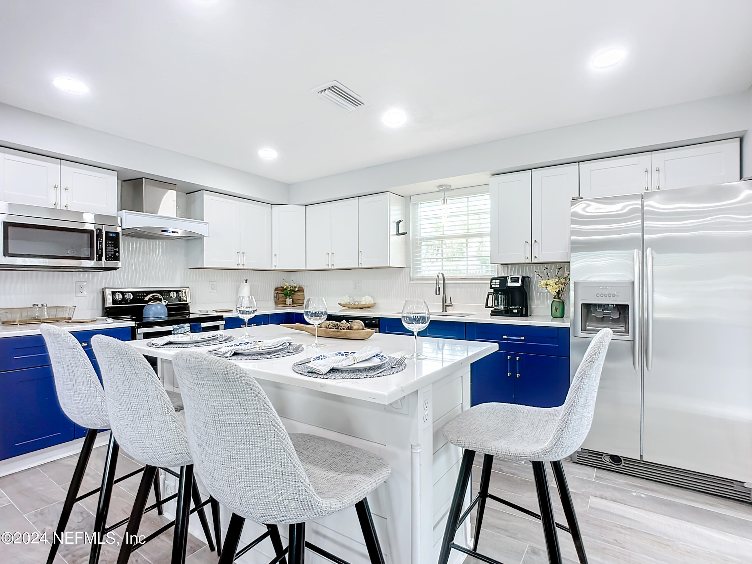 54 Surf Drive St. Augustine, FL 32080 - Photo 16 of 47 a kitchen with stainless steel appliances granite countertop a dining table chairs refrigerator and cabinets