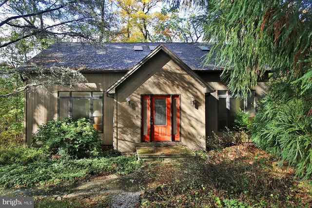 a view of brick house with large windows and a small yard