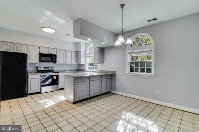a kitchen with a refrigerator a sink stainless steel appliances and cabinets