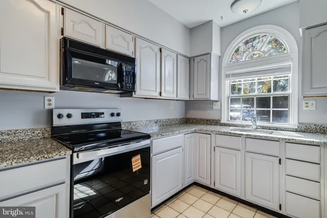 a kitchen with stainless steel appliances granite countertop a stove microwave and cabinets