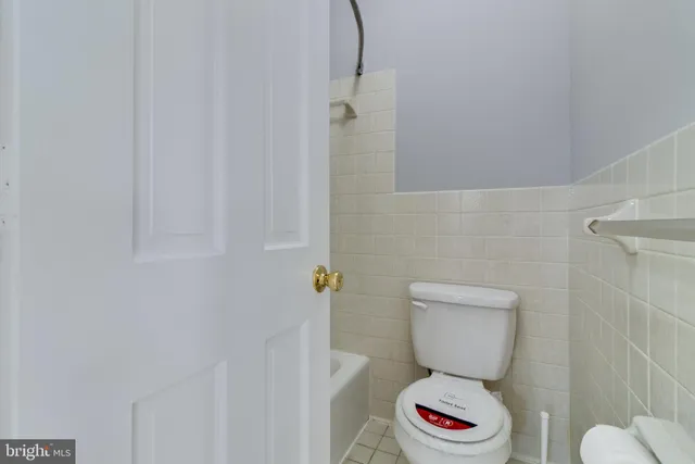 a white toilet sitting next to a bathroom