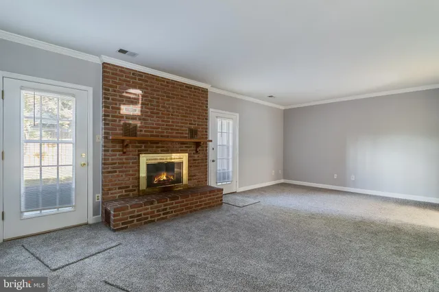 a view of an empty room with a fireplace and a window