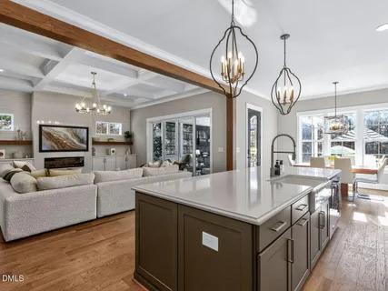 a large kitchen with kitchen island a stove a sink a oven and a chandelier