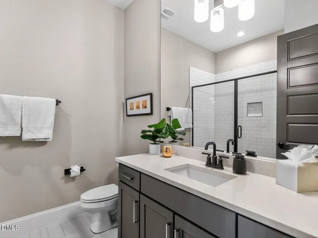 a bathroom with a double vanity sink toilet and mirror