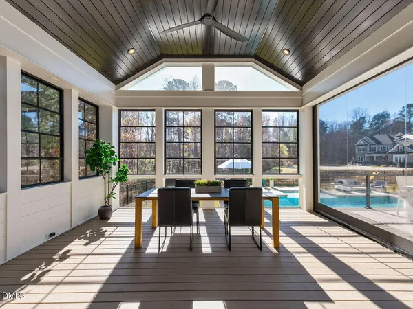 a view of a dining room with furniture large windows and wooden floor