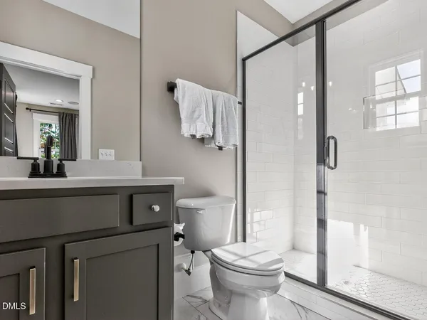 a bathroom with a sink a toilet and a mirror