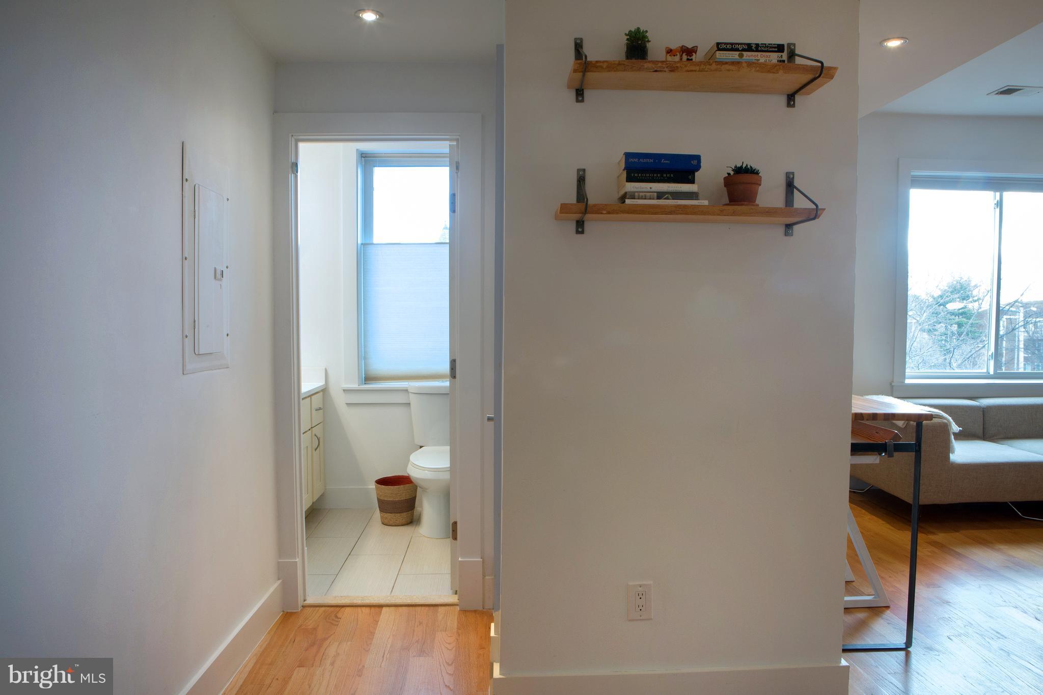 1700 2nd Street Northwest, Unit 9 Washington, DC 20001 - Photo 13 of 26 a view of a hallway with wooden floor and a bathroom