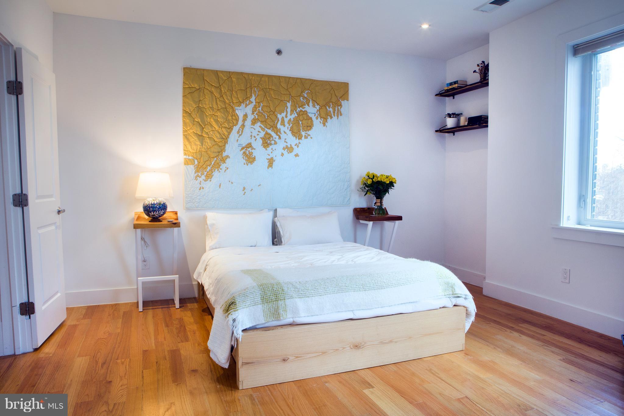 1700 2nd Street Northwest, Unit 9 Washington, DC 20001 - Photo 19 of 26 a bedroom with a bed and a painting on the wall