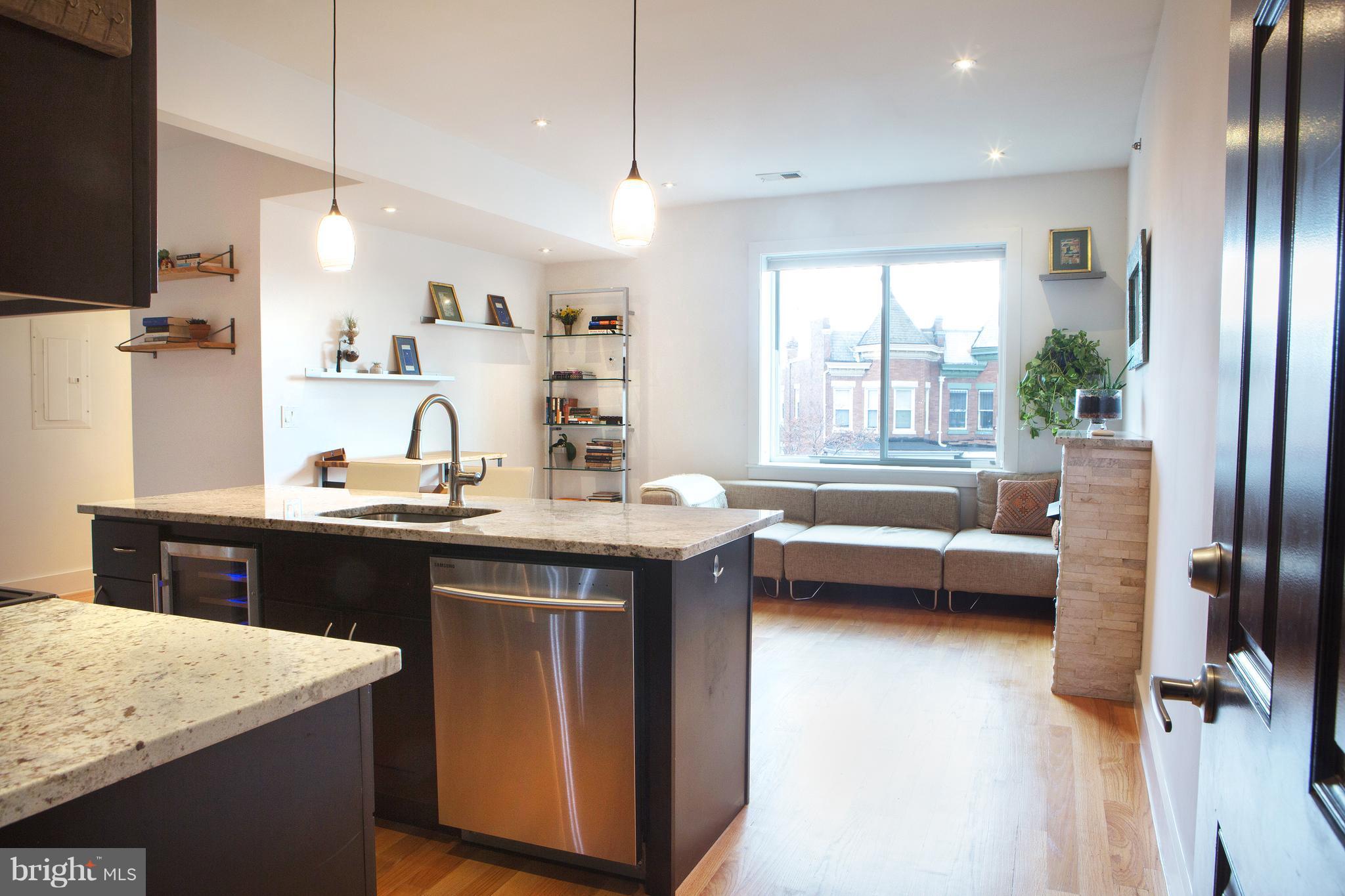 1700 2nd Street Northwest, Unit 9 Washington, DC 20001 - Photo 3 of 26 a kitchen with kitchen island granite countertop a sink a counter top space and stainless steel appliances